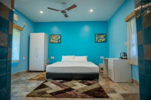a blue bedroom with a bed and a blue wall at Michael's Island Resort in Sātpāra