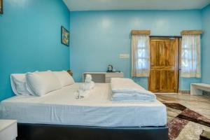 a blue bedroom with a large bed with towels on it at Michael's Island Resort in Sātpāra