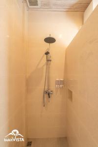 a shower with a shower head in a bathroom at Kembang Kuning in Uluwatu
