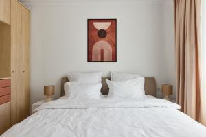 a bedroom with a white bed with white pillows at 20 Apartment Centre in Bucharest