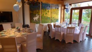 a dining room with white tables and white chairs at B&B de Luijenbergh in Oud-Gastel