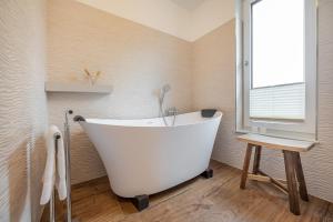 a white bath tub in a bathroom with a window at Ferienwohnung Blickwinkel in Lohme
