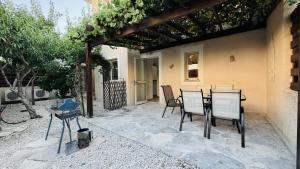 a patio with a table and chairs in front of a house at Villa Anastasia ,150 m to Coral Bay beach in Peyia