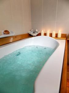 a bath tub filled with blue water next to candles at Skiathos Driades in Koukounaries