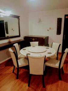 a dining room with a table and chairs and a mirror at Nuwaraeliya Penthouse Apartment with pool & Panaromic Views in Nuwara Eliya