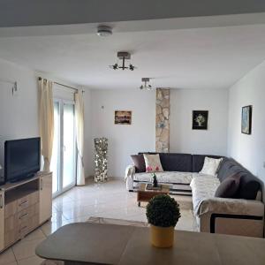 a living room with a couch and a tv at Montenegro Smile in Dobra Voda