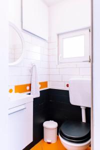 a bathroom with a toilet and a sink and a window at Cozy flat in Center in Maribor
