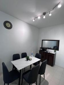 a dining room with a table and chairs and a tv at Ayaan Cozy Homestay Cameron Highland in Tanah Rata +17 photos