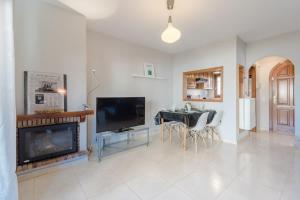 a living room with a fireplace and a dining room at Casa Azahara by MarCalma in El Casalot