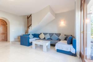 a living room with a blue couch and a table at Casa Azahara by MarCalma in El Casalot +16 photos