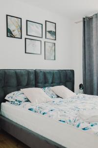 a bed with a blue and white comforter in a bedroom at Apartamenty przy Dworku in Człuchów