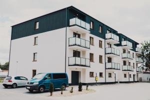 a blue van parked in front of a building at Apartamenty przy Dworku in Człuchów