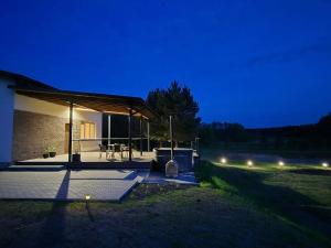 a house with a lit up patio at night at Sodyba Azagis in Vilkanastrai