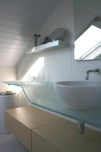 baño con lavabo blanco y ventana en B&B Le Jardin d'Epicure, en Olne