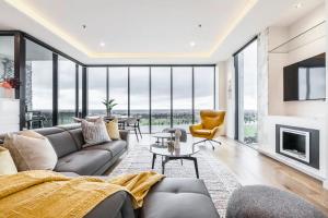a living room with a couch and a fireplace at Opulent & Spacious Condo Overlooking Albert Park in Melbourne