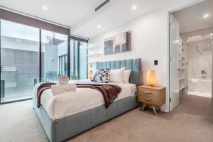 a bedroom with a king sized bed and a window at Opulent & Spacious Condo Overlooking Albert Park in Melbourne