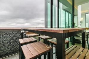 a bar with benches and tables on a balcony at Opulent & Spacious Condo Overlooking Albert Park in Melbourne