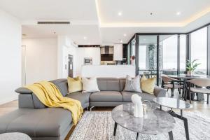a living room with a couch and tables at Opulent & Spacious Condo Overlooking Albert Park in Melbourne