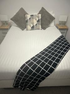 a bed with a black and white comforter on it at FLEMINGTON - Melbourne City Views in Melbourne +13 photos