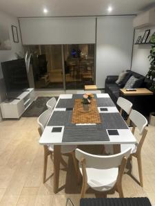 a living room with a white table and chairs at FLEMINGTON - Melbourne City Views in Melbourne