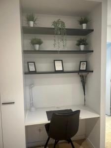 a desk with a chair and shelves with plants at FLEMINGTON - Melbourne City Views in Melbourne