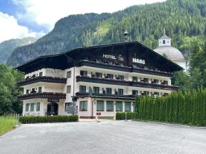 a large white building with a mountain in the background at Hotel HAAS in Bad Gastein