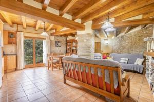 a kitchen and living room with a wooden ceiling at El Raco De Cal Maró in Vall de Castellbò +19 photos