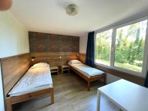 a room with two beds and a window at Brzozowa Zatoka Brenno in Brenno +101 photos