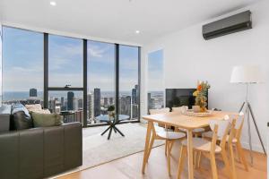 a living room with a table and a couch at Sleek Lvl 75 Apt w Skyline Views in Aurora Complex in Melbourne