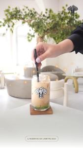 a person is stirring a drink with a spoon at The Garden Suites New in Solo