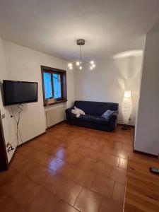 a living room with a couch and a flat screen tv at Sole e Neve -Sun & Snow in Forno di Zoldo