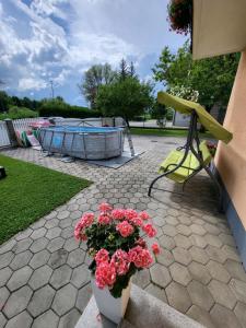 a patio with a table and flowers and a pool at Apartmaji Peric in Ljubljana