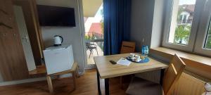 a small room with a table and a television on a window at Willa Lazur in Władysławowo