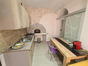 cocina con encimera, mesa y fogones en Royal Suite, en Santa Domenica