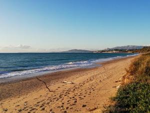 a beach with footprints in the sand and the ocean at White Lotus in Ribera
