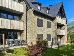 a building with a table and chairs in a yard at Luderna - Apartamento con jardín Marconi in Arties
