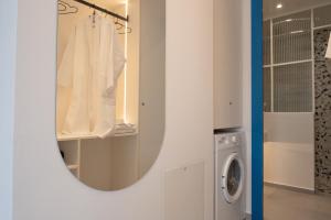a bathroom with a mirror and a washing machine at Infinity Blue next to the sea in Kalamata