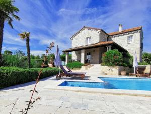 una casa con piscina di fronte a una casa di Family Villa Blum a Dobrinj