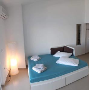 łóżko z niebieską pościelą i białymi poduszkami w pokoju w obiekcie Apartment Zvonko w mieście Metajna