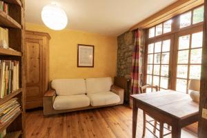 Una sala de estar con una silla y una mesa. en Les Grisiéres, en Montpezat-sous-Bauzon
