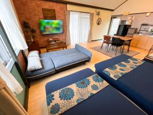 a living room with a couch and a tv at Yukurina Resort Okinawa in Motobu