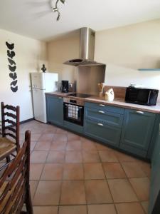 a kitchen with blue cabinets and a white refrigerator at Cottage du Marais in Bazinghen +15 photos
