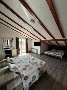 a attic bedroom with a bed and a desk at Apartment and Room Marlen in Rovinjsko Selo