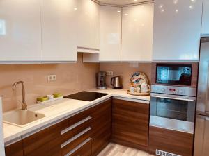 a kitchen with white cabinets and a sink at Comfy Camel Apartment in Budapest