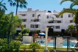 a large white building with a pool and palm trees at Ona Campanario in La Cala de Mijas
