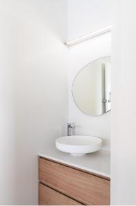 a white bathroom with a sink and a mirror at No 3 ShoalHaven in Shoal Bay