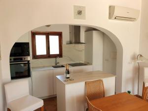 a kitchen with a table and a bottle of wine at Villa Casa Nuestra in Moraira +36 photos