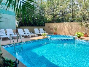 a swimming pool with chairs next to a fence at Europe Holiday Apartments First Sea Line Coast in Pomorie