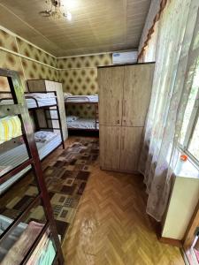 a room with several bunk beds and a room with a door at Lovely home for you in Osh