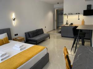 a bedroom with a bed and a table and a kitchen at Thess Living Suites in Thessaloniki